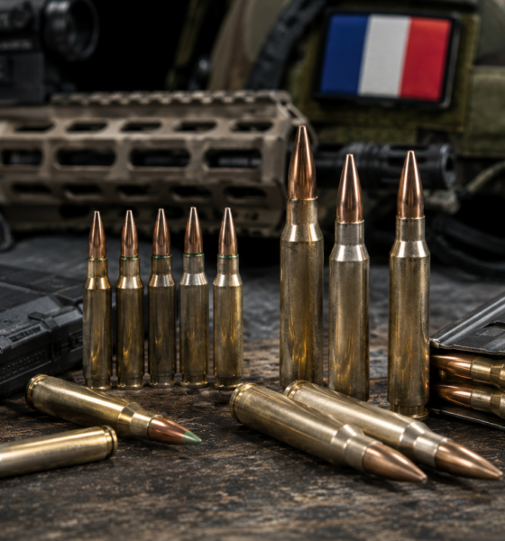Cartouches de 5,56 et 7,62 mm devant un fusil et un drapeau français