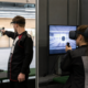 Un tireur au pistolet à côté d'une personne équipée d'un casque de réalité virtuelle sur un pas de tir