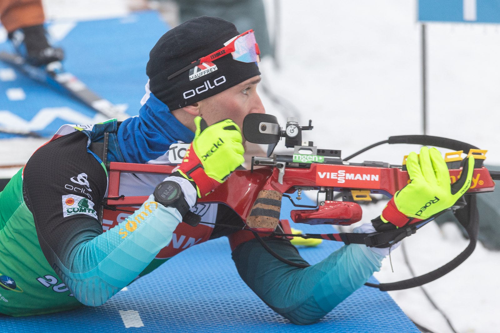 Gros plan sur un biathlète au tir couché avec sa carabine en 22 LR